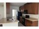 Well-lit kitchen features ample cabinet space, double sinks, and black appliances at 3166 Riachuelo Ln, Kissimmee, FL 34744