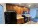 Kitchen featuring plentiful wood cabinets, black appliances, and a large refrigerator at 3166 Riachuelo Ln, Kissimmee, FL 34744