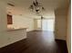 Open-concept living room with vinyl floors, fan, and breakfast bar to the kitchen at 3166 Riachuelo Ln, Kissimmee, FL 34744