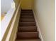 Upward view of interior stairway featuring wood steps, white risers and handrail at 3166 Riachuelo Ln, Kissimmee, FL 34744