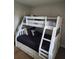 A bedroom with a white bunk bed offering drawers for storage and a ladder for access at 3500 Calabria Ave, Davenport, FL 33897