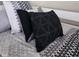 Close up of bedroom with decorative pillows and textured bedding in shades of gray and black at 3500 Calabria Ave, Davenport, FL 33897