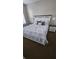 Well-lit bedroom with decorative pillows and lamps atop matching nightstands at 3500 Calabria Ave, Davenport, FL 33897