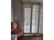 Bedroom with a chair in the corner of the room, overlooking the backyard with plantation shutters at 3500 Calabria Ave, Davenport, FL 33897