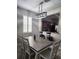 Well-lit dining area features a wooden table with seating for six, a modern chandelier, and a view of the kitchen at 3500 Calabria Ave, Davenport, FL 33897