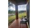 Relaxing patio with two chairs overlooking a green lawn with trees and a wooden fence at 3500 Calabria Ave, Davenport, FL 33897