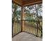 Outdoor patio view with a metal railing, offering a glimpse of the fenced backyard and surrounding trees at 3500 Calabria Ave, Davenport, FL 33897
