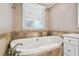 Bright bathroom features a soaking tub under a window at 3520 N Westmoreland Dr, Orlando, FL 32804