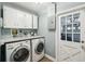 Functional laundry room with washer, dryer, cabinets, and backyard access at 3520 N Westmoreland Dr, Orlando, FL 32804