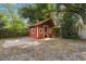 Exterior view of a backyard shed with brick trim and mature landscaping around the perimeter at 3520 N Westmoreland Dr, Orlando, FL 32804