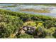 An aerial view of a private estate surrounded by lush trees and lake views showcasing an idyllic and secluded retreat at 40137 County Road 452, Leesburg, FL 34788