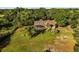 Aerial view of the property showcasing a well-manicured lawn, mature trees, and a screened in patio for seamless outdoor living at 40137 County Road 452, Leesburg, FL 34788