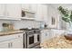 Bright kitchen featuring granite countertops, stainless steel stove, and white cabinetry at 40137 County Road 452, Leesburg, FL 34788