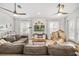 Spacious living room featuring a large sectional sofa, decorative ceiling fans, and shiplap accent wall at 40137 County Road 452, Leesburg, FL 34788