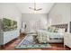 Comfortable primary bedroom featuring hardwood floors, a ceiling fan, and bright, stylish accents at 40137 County Road 452, Leesburg, FL 34788