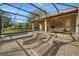 Enjoy sunbathing on the brick paved patio with two lounge chairs by the screened in pool, surrounded by lush greenery at 40137 County Road 452, Leesburg, FL 34788