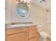 Bathroom with round mirror over the vanity and a shower with tile surround at 419 Sheoah Blvd # 27, Winter Springs, FL 32708