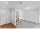 Bright hallway featuring white walls, wood floors, and a glimpse of a modern bathroom at 42 W Harding St # E, Orlando, FL 32806