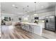 Bright, modern kitchen with stainless appliances, an island with seating and an open concept living and dining area at 42 W Harding St # E, Orlando, FL 32806