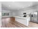 Open-concept kitchen featuring stainless steel appliances, a kitchen island and lots of natural light and wood flooring at 42 W Harding St # E, Orlando, FL 32806