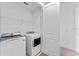 A laundry room featuring a washer and dryer, storage shelving and a door leading to another room at 42 W Harding St # E, Orlando, FL 32806