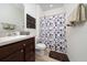 Bathroom features modern dark wood vanity, sink, a decorative shower curtain, and neutral tile flooring at 426 Citrus Isle Loop, Davenport, FL 33837