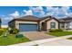 Charming single Gathering home featuring a blue garage door and shutters with a well-manicured lawn at 426 Citrus Isle Loop, Davenport, FL 33837