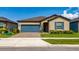 Charming single Gathering home featuring a blue garage door and shutters with a well-manicured lawn at 426 Citrus Isle Loop, Davenport, FL 33837