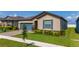 Charming single Gathering home featuring a blue garage door and shutters with a well-manicured lawn at 426 Citrus Isle Loop, Davenport, FL 33837