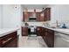 Kitchen with stainless steel appliances, wood cabinets, tile floors and white countertops at 426 Citrus Isle Loop, Davenport, FL 33837