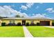 Charming single-story home with a well-manicured lawn, beautiful shrubbery and attached two car garage at 4640 Chateau Rd, Orlando, FL 32808