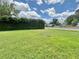 Expansive front yard showcasing lush green grass and privacy hedges along the property line at 4640 Chateau Rd, Orlando, FL 32808