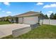 View of the home's facade, long driveway, two-car garage, and manicured lawn at 4811 Sw 108Th Place Rd, Ocala, FL 34476