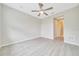 A bedroom with a ceiling fan, light grey floors, and a view of an adjacent hallway at 5215 Nw 34Th St, Ocala, FL 34482