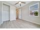 Bright bedroom featuring gray wood-look tile floor, ceiling fan, window and closet at 5215 Nw 34Th St, Ocala, FL 34482