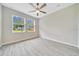 Bright bedroom featuring a ceiling fan, two windows, and light grey floors for a clean, modern look at 5215 Nw 34Th St, Ocala, FL 34482