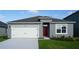 Charming single-story home with a two-car garage and red front door at 5860 Galloping Dr, Apopka, FL 32712