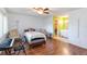 Spacious bedroom with wood flooring, a ceiling fan, access to bathroom, and a comfortable bed and chairs at 6 Escondido Cir # 55, Altamonte Springs, FL 32701