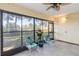 Enclosed sunroom featuring tiled floors, two chairs, and large windows overlooking the community green space at 6 Escondido Cir # 55, Altamonte Springs, FL 32701