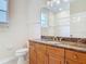 Bathroom features a marble-look counter, wooden cabinets, and tiled shower at 600 Garden Club Dr, Deland, FL 32724