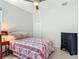 Cozy bedroom with a ceiling fan, closet, and large bed with colorful floral design at 600 Garden Club Dr, Deland, FL 32724