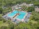 Aerial view of a large community pool surrounded by lush greenery, pergolas and lounge chairs at 600 Garden Club Dr, Deland, FL 32724