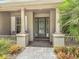 Inviting front entrance with decorative glass door, columns, and manicured flower beds at 600 Garden Club Dr, Deland, FL 32724