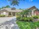 Beautiful single-story home featuring a paver driveway and vibrant landscaping beneath a clear, sunny sky at 600 Garden Club Dr, Deland, FL 32724