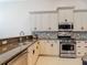 Well-equipped kitchen featuring stainless steel appliances, granite countertops, and mosaic tile backsplash at 600 Garden Club Dr, Deland, FL 32724