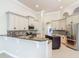 Spacious kitchen with white cabinets, stainless steel appliances, and center island with granite countertop at 600 Garden Club Dr, Deland, FL 32724