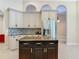 Kitchen featuring white cabinetry, stainless refrigerator, and a dark kitchen island with granite countertop at 600 Garden Club Dr, Deland, FL 32724