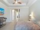 Bright main bedroom with tray ceiling and tile flooring plus TV and console at 600 Garden Club Dr, Deland, FL 32724