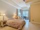 Bright main bedroom with tray ceiling, tile floor, sitting area, and lots of natural light at 600 Garden Club Dr, Deland, FL 32724