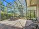 Screened patio featuring a dining area, lounge chairs, and lush green surroundings at 600 Garden Club Dr, Deland, FL 32724